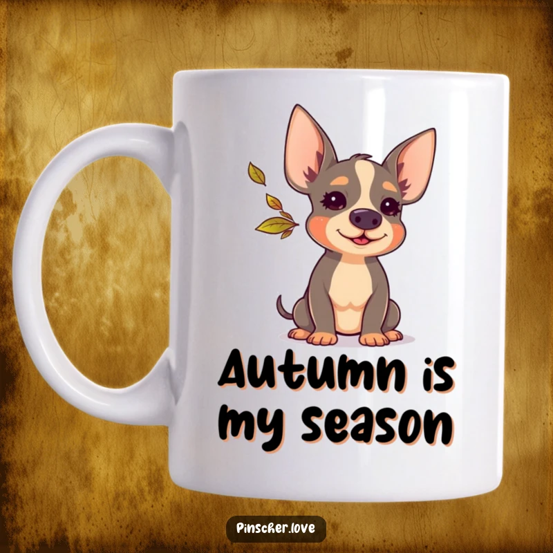 Funny Pinscher mug depicting a Pinscher dog happily blowing a small, colorful autumn leaf with a joyful puff of air.