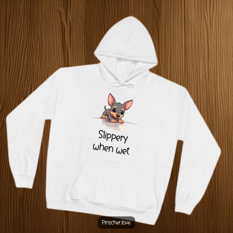 Funny Pinscher Hoodie showing a dog hilariously slipping on a slick surface, perfect for cozy, humorous wear.
