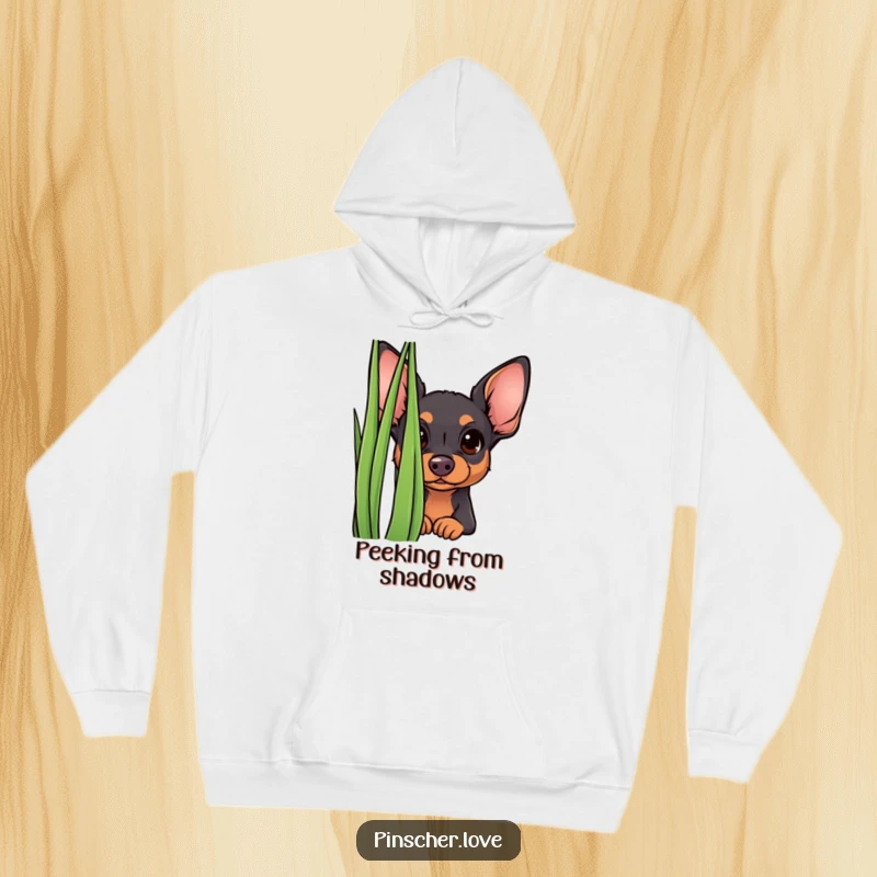 Funny curious pinscher hoodie, showing a small dog peeking from behind grass. Cozy and humorous apparel for playful souls.
