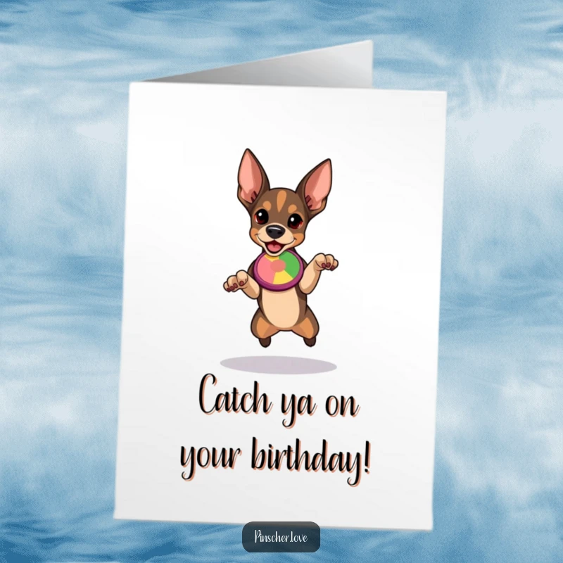 Free Printable Birthday Card, determined Pinscher dog in mid-stance, ready to leap for a colorful flying disc, full of energy.