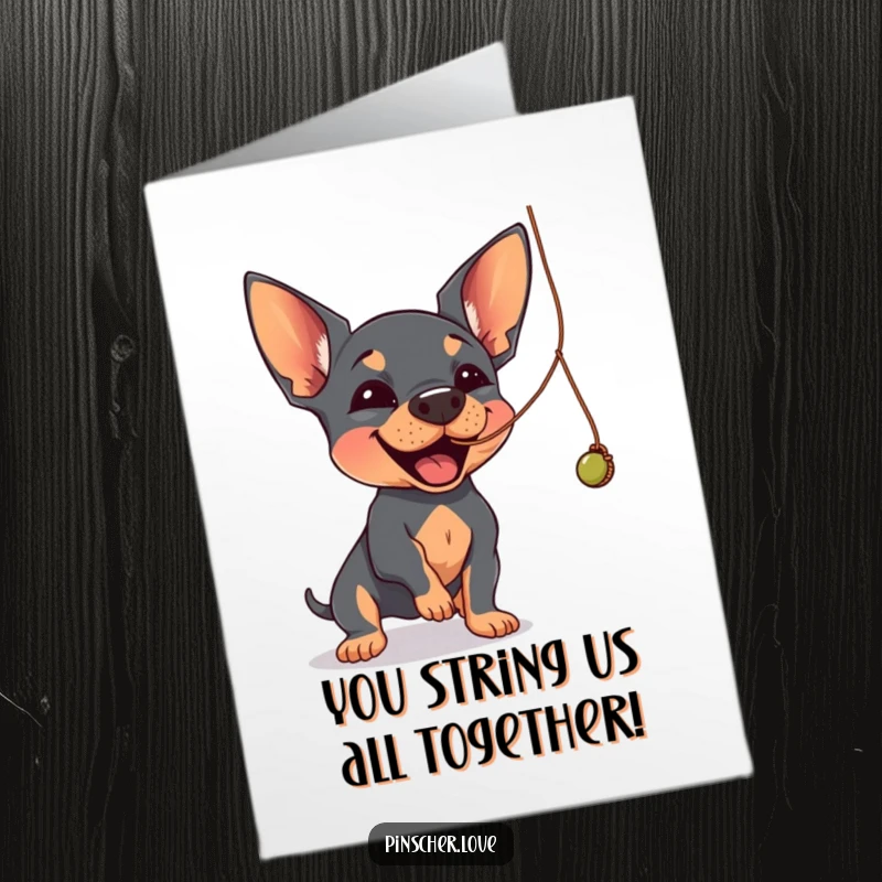 Funny Free Printable Congratulations Card: A happy Pinscher enthusiastically batting at a dangling, wobbly string, celebrating joyfully.