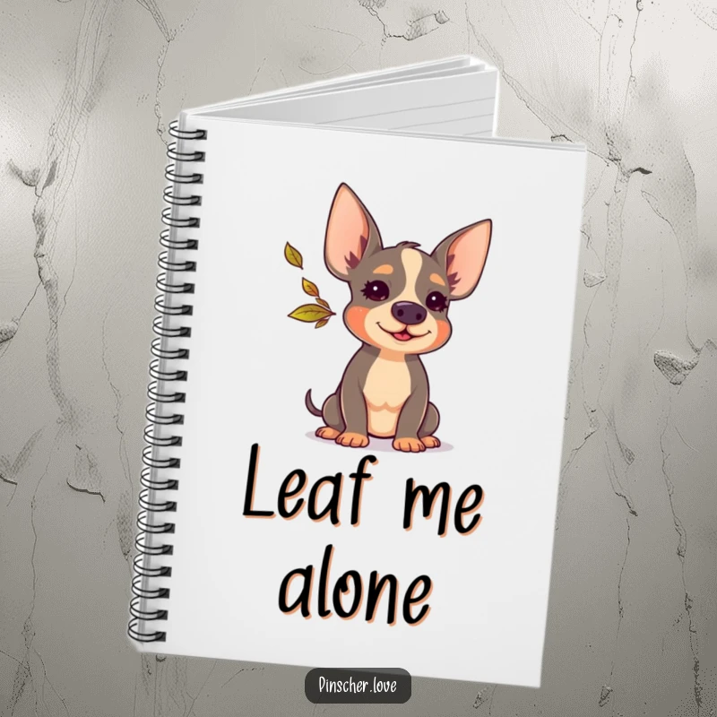 Funny Pinscher notebook showcasing a cute dog blowing a small, colorful autumn leaf, ideal for jotting down notes with a smile.