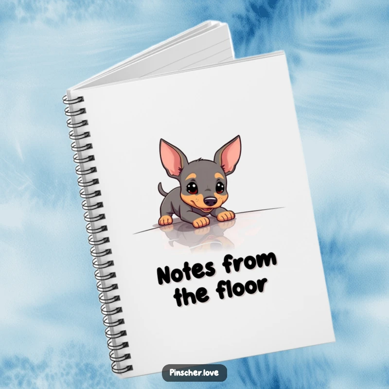 Funny Pinscher Notebook showing a dog comically slipping on a slick surface, ideal for jotting down notes with humor.