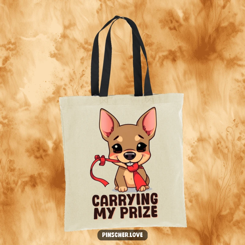 Funny Pinscher tote bag illustrated with a mischievous dog grinning while playfully snagging a dangling red ribbon, highlighting impish charm.