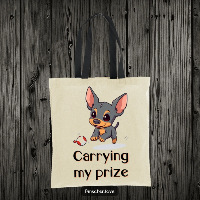 Funny pinscher tote bag depicting an energetic pinscher dog determinedly chasing a small, fleeing toy with playful focus.