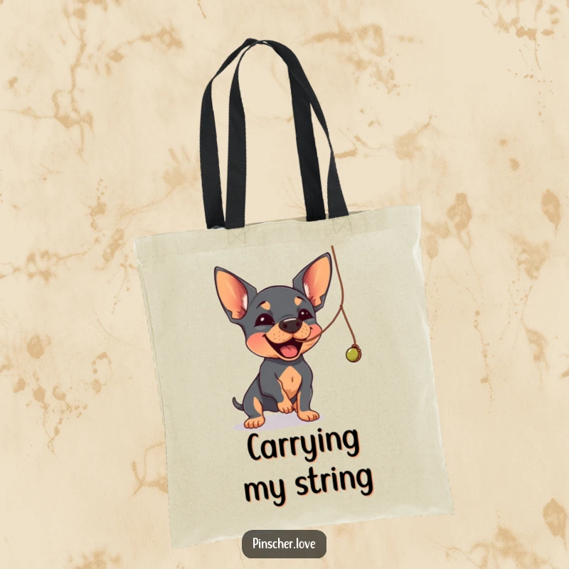 Funny Pinscher tote bag depicting a Pinscher dog joyfully batting at a dangling, wobbly string.