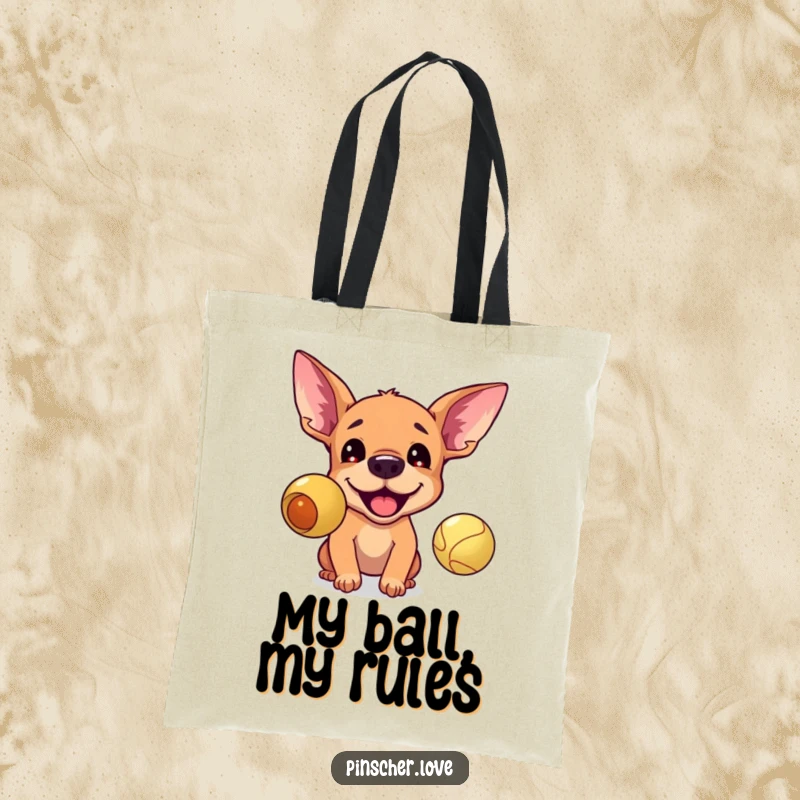 Funny tote bag illustrating an excited pinscher with perked ears, intensely barking at a bouncing ball, ideal for dog park trips.