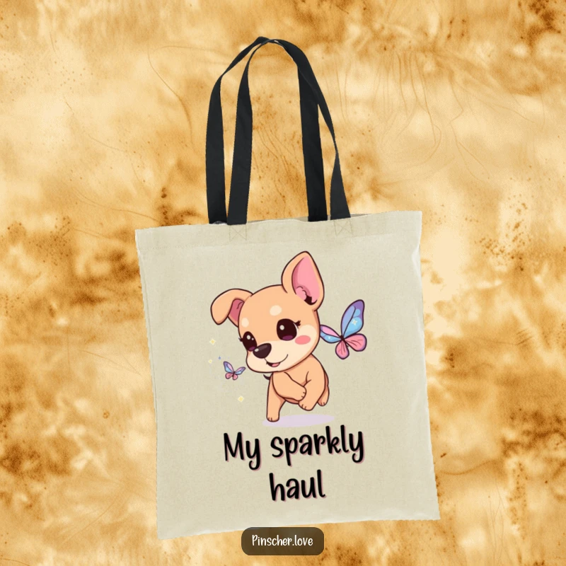 Funny Pinscher Tote Bag: A happy pinscher dog with twinkling eyes chases a butterfly made of glittery, magical sparkles, adding whimsy.