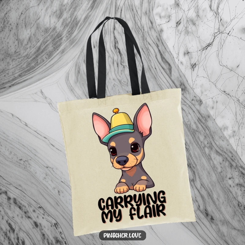 Funny Pinscher tote bag with a proud dog expertly balancing a colorful hat on its nose, perfect for carrying essentials with flair.