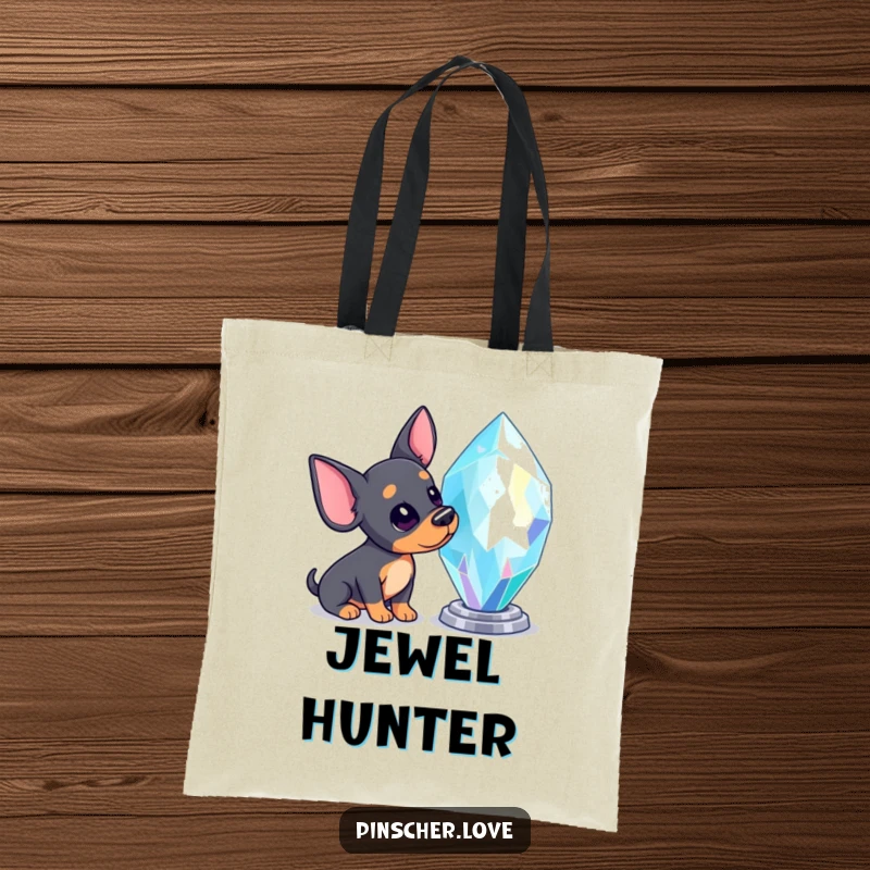 Funny Pinscher tote bag featuring a Pinscher dog tilting its head, mesmerized by a large, brilliantly sparkling gem.