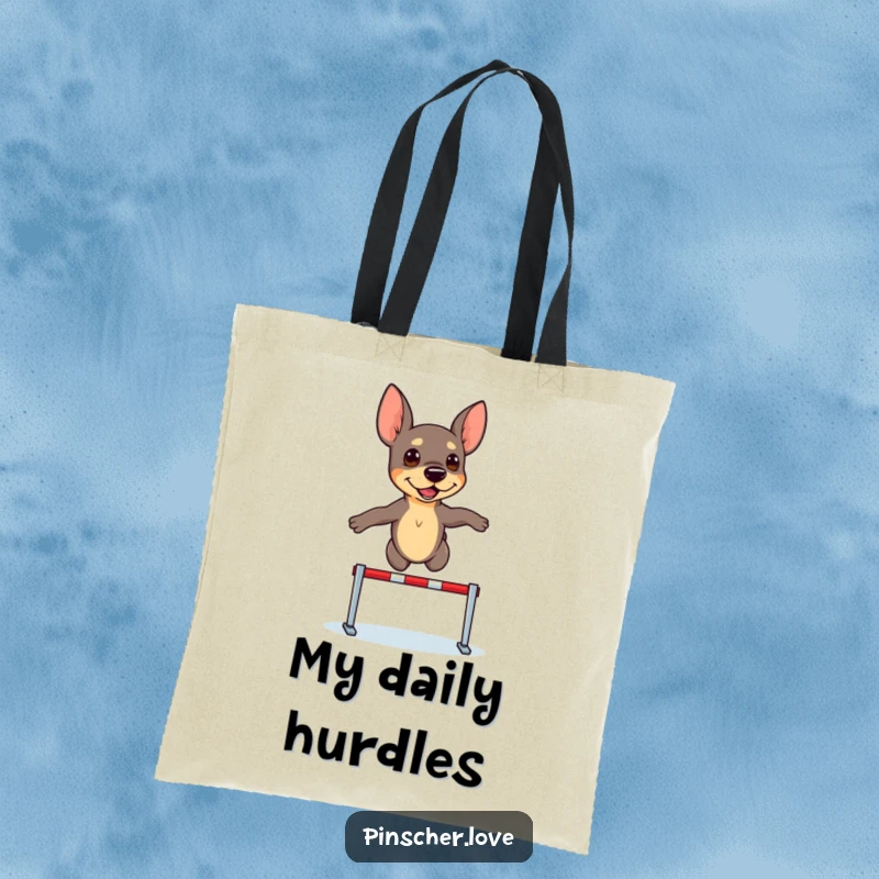 Funny Pinscher Tote Bag: A determined pinscher dog leaps over a minuscule hurdle, ready for any challenge.